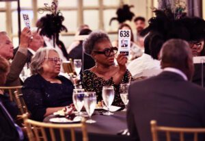Woman holding up her paddle with the number 638 during the live auction at the Front Steps Elevation Gala